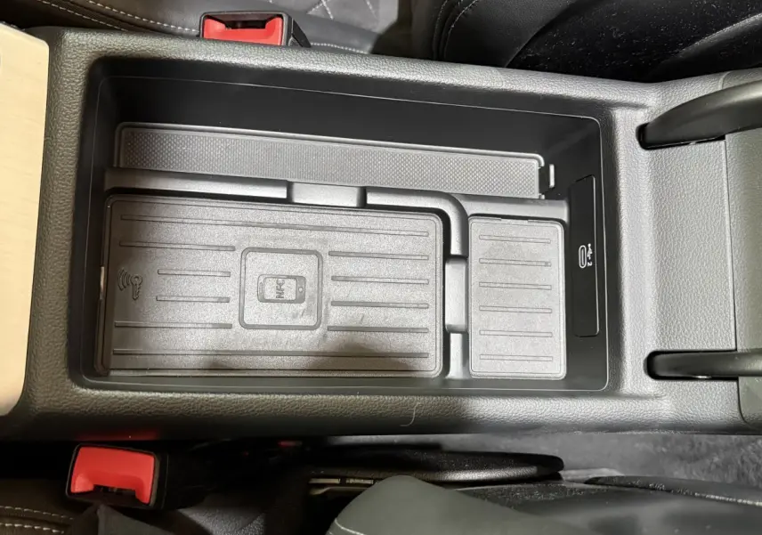 Vue plongeante sur la zone de recharge sans fil noire au centre de l'habitacle de l'Audi A4 gris foncé.