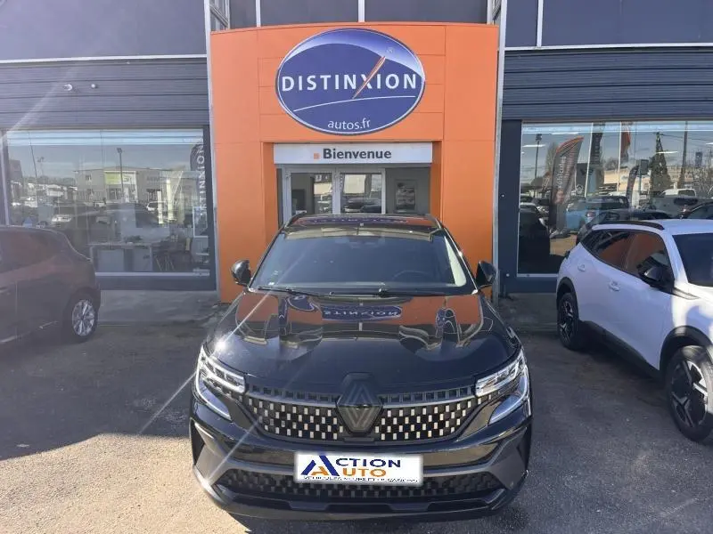 Vue avant d'un Renault Austral noir étoilé garé devant un concessionnaire avec calandre distinctive et phares LED.