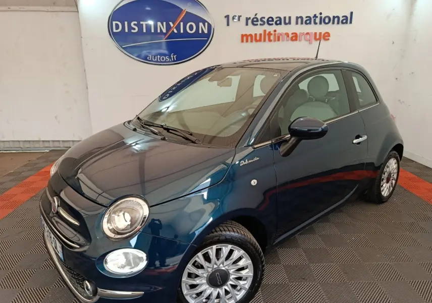 Vue 3/4 avant droite d'une Fiat 500 Dolcevita bleue avec jantes alliage et logo distinctif sur l'aile avant.