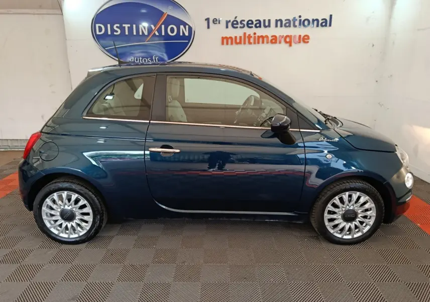 Profil droit d'une FIAT 500 Dolcevita bleu profond, avec jantes alliage et logo distinctif sur l'aile avant.