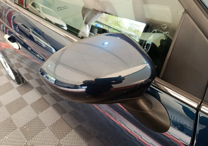 Rétroviseur côté gauche bleu brillant de la Fiat 500 Hybrid 2022, avec reflet de l'environnement intérieur.