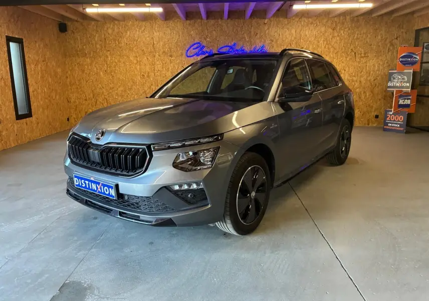 Vue 3/4 avant droite du Skoda Kamiq gris foncé 2024 avec calandre noire et jantes spécifiques Monte-Carlo.