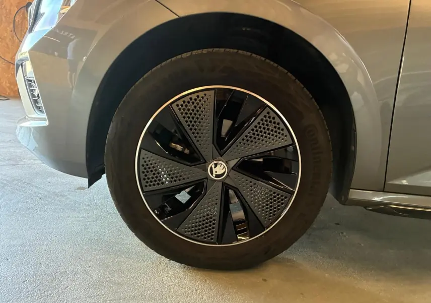 Gros plan sur la roue avant gauche du Skoda Kamiq gris foncé 2024 avec jante noire et argentée au design moderne.