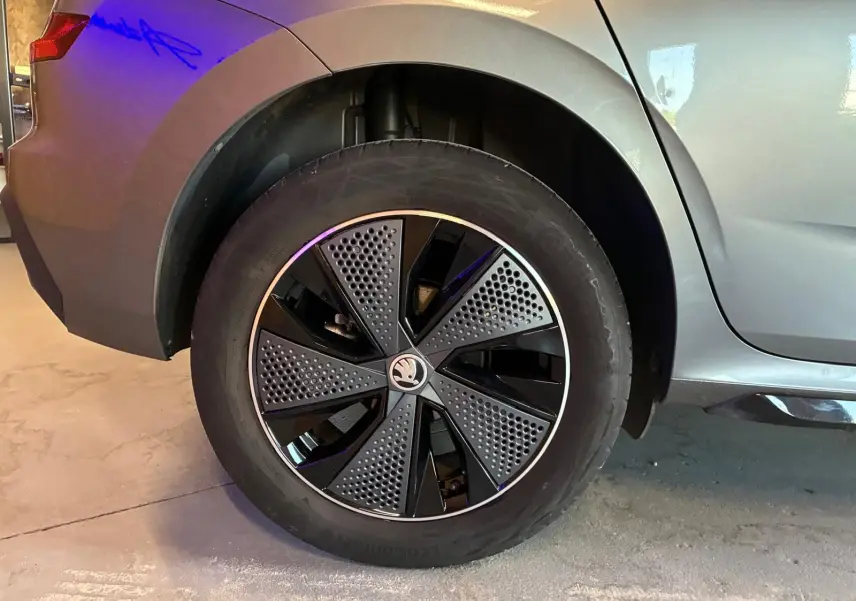 Gros plan sur la roue arrière droite du Skoda Kamiq gris foncé 2024, mettant en valeur la jante au design moderne bicolore.