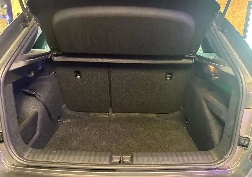 Coffre ouvert vu de l'arrière d'un Skoda Kamiq gris foncé 2024, montrant un espace de chargement vide et propre.