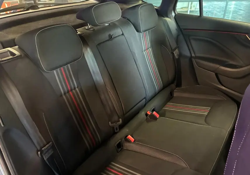 Vue intérieure arrière du Skoda Kamiq 2024 gris foncé, sièges tissu noir avec bandes rouges et grises distinctives.