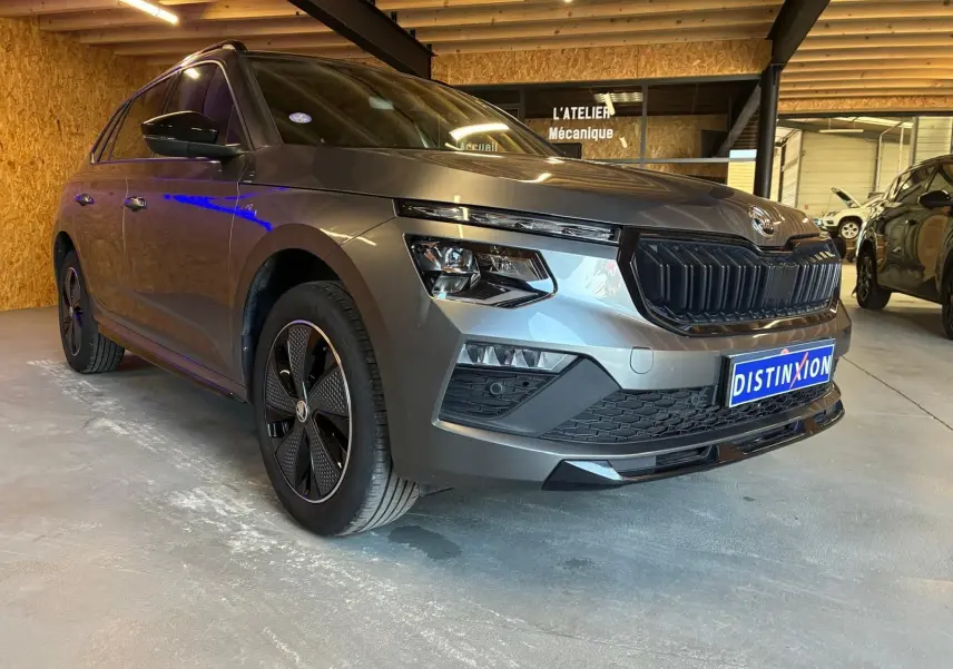 Skoda Kamiq 1.5 TSI 2024 gris foncé en 3/4 avant gauche, avec calandre noire et jantes spécifiques Monte-Carlo.