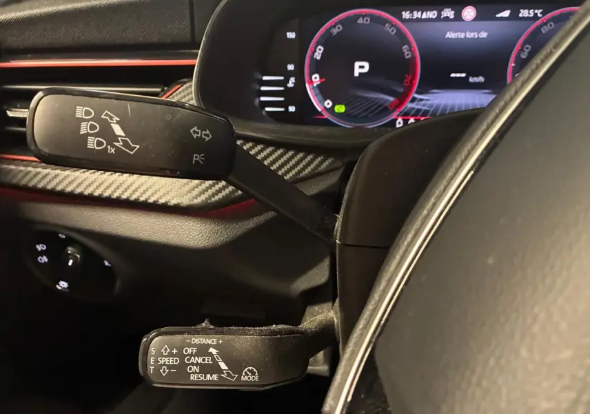 Gros plan sur les commandes au volant et le tableau de bord numérique du Skoda Kamiq gris foncé, version Monte-Carlo 2024.