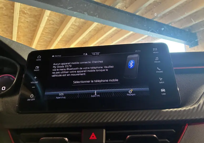 Écran tactile central du tableau de bord d’une Skoda Kamiq 2024, affichant le menu Bluetooth, avec finition carbone et touches tactiles.