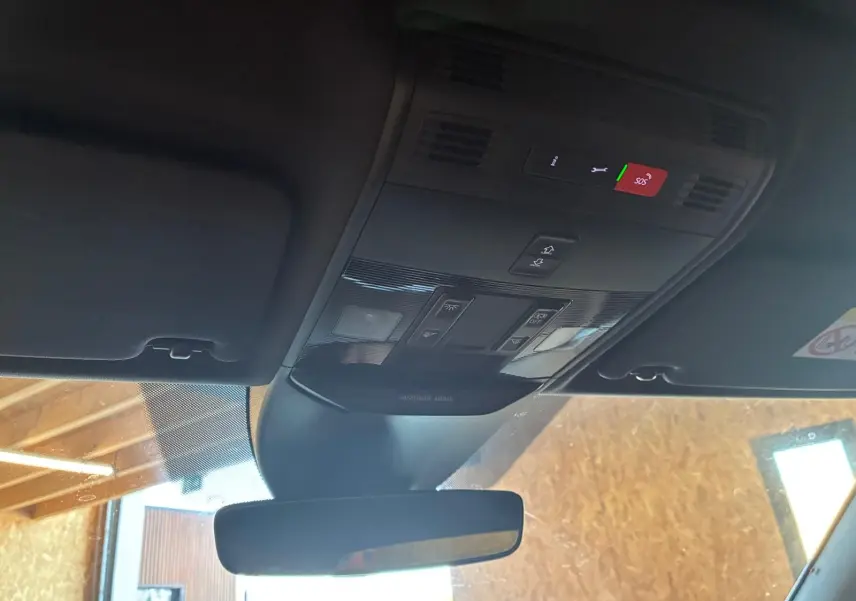 Vue intérieure du plafond avant d'une Skoda Kamiq 2024 gris foncé, avec commandes d'éclairage et rétroviseur central visible.