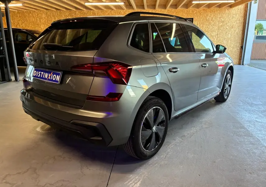 Vue 3/4 arrière droite du Skoda Kamiq gris foncé 2024 avec jantes noires et feux arrière LED distinctifs.