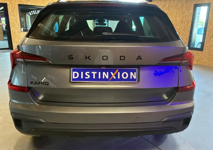Vue arrière d'un Skoda Kamiq gris foncé 2024 avec feux arrière LED et logo SKODA en lettres espacées.