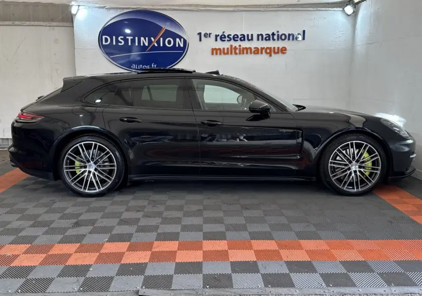 Vue latérale droite d'une Porsche Panamera 4 E-Hybrid Sport Turismo noire avec jantes alliage et étriers de frein verts.