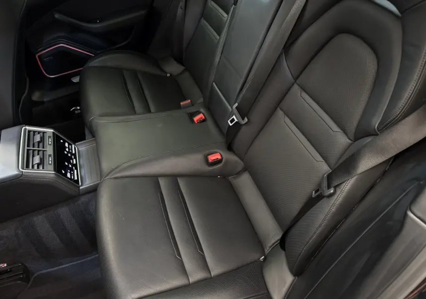 Vue intérieure des sièges arrière noirs en cuir de la Porsche Panamera 4 E-Hybrid Sport Turismo 2018 avec console centrale tactile.
