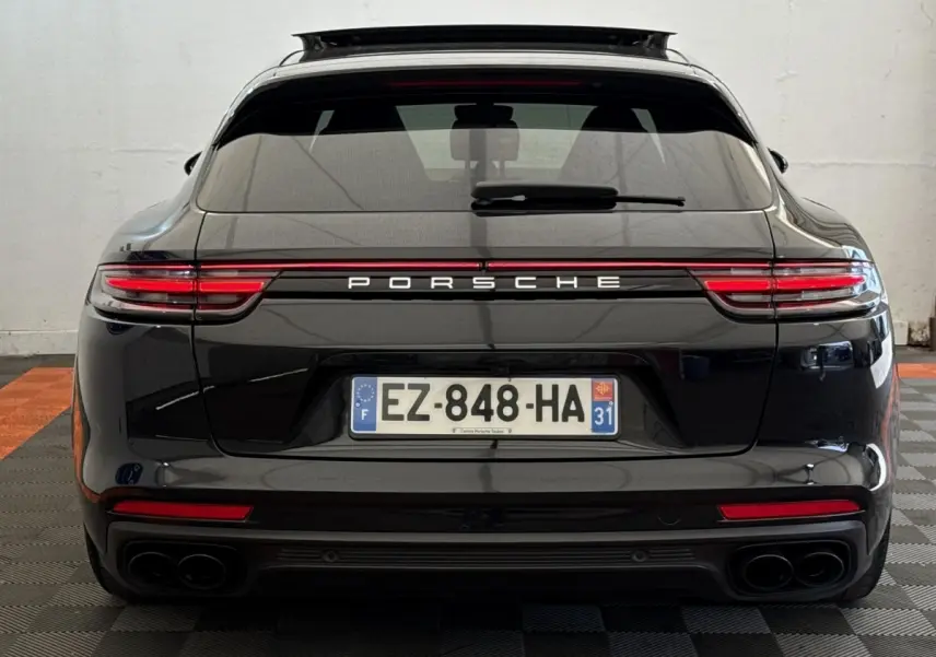Vue arrière d'une Porsche Panamera 4 E-Hybrid Sport Turismo noire, avec feux LED et double sortie d'échappement.