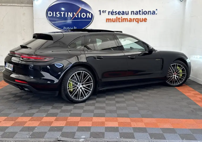 Vue de profil droit d'une Porsche Panamera 4 E-Hybrid Sport Turismo noire avec jantes alliage et étriers de frein verts.