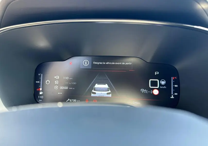 Vue du tableau de bord numérique du Citroën C5 Aircross 2025, affichage en mode stationnement avec alertes visibles.