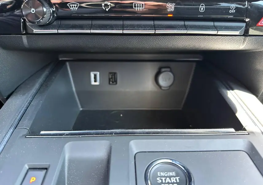 Gros plan intérieur sur la console centrale noire avec bouton démarrage, prises USB et prise 12V du Citroën C5 Aircross.