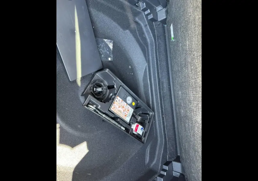 Gros plan sur le coffre du Citroën C5 Aircross 2025 gris Platinium, montrant le kit de réparation pneus intégré.