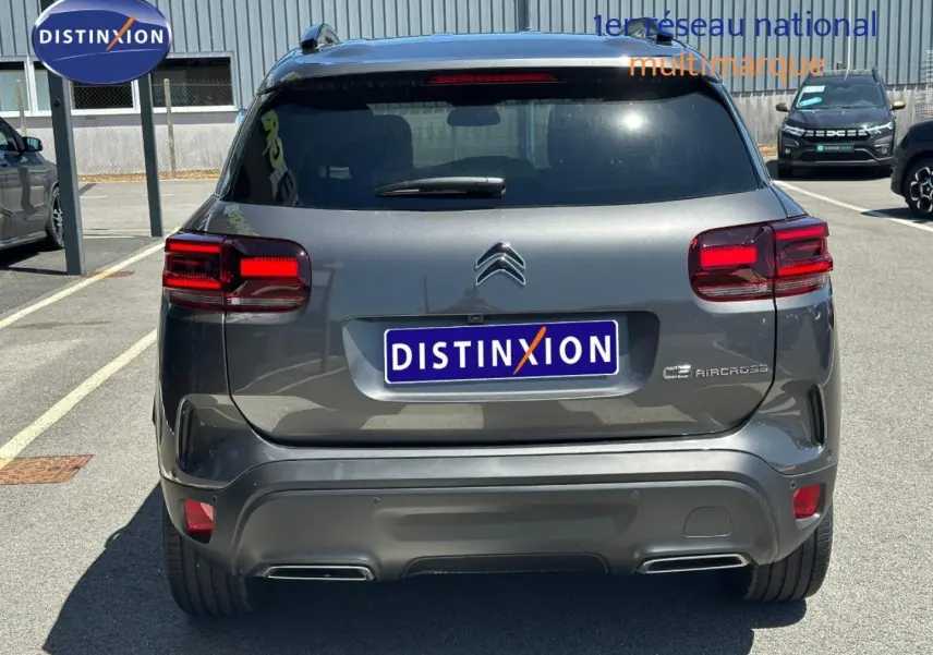 Vue arrière d'un Citroën C5 Aircross gris Platinium avec feux arrière LED et double sortie d'échappement intégrée.