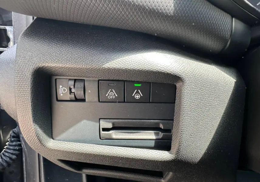 Gros plan sur les commandes d'assistance à la conduite à gauche du volant dans un Citroën C5 Aircross gris Platinium.
