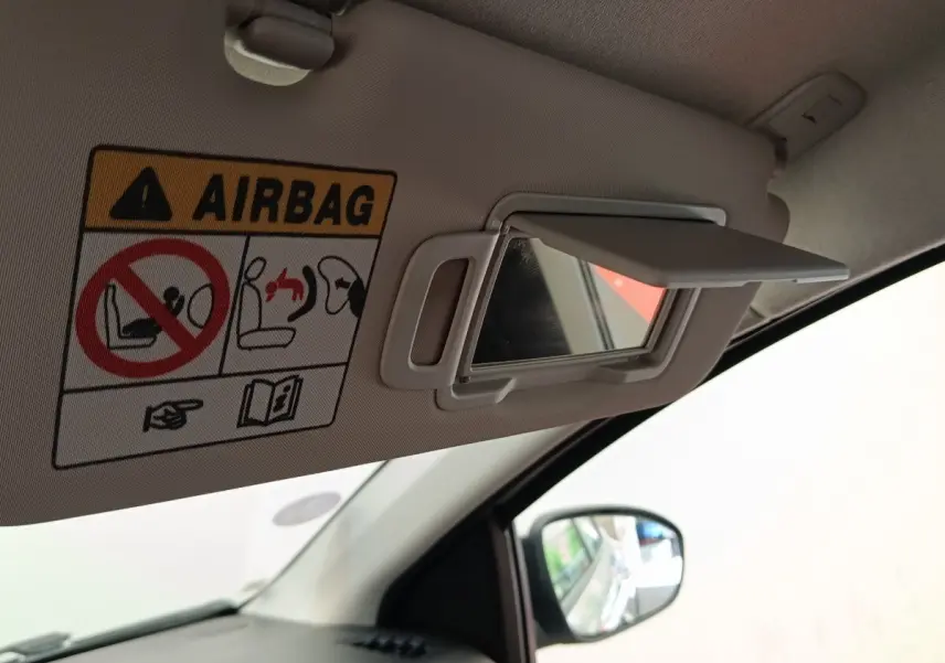 Détail du pare-soleil côté conducteur avec miroir de courtoisie ouvert dans une Dacia Sandero gris clair 2023.