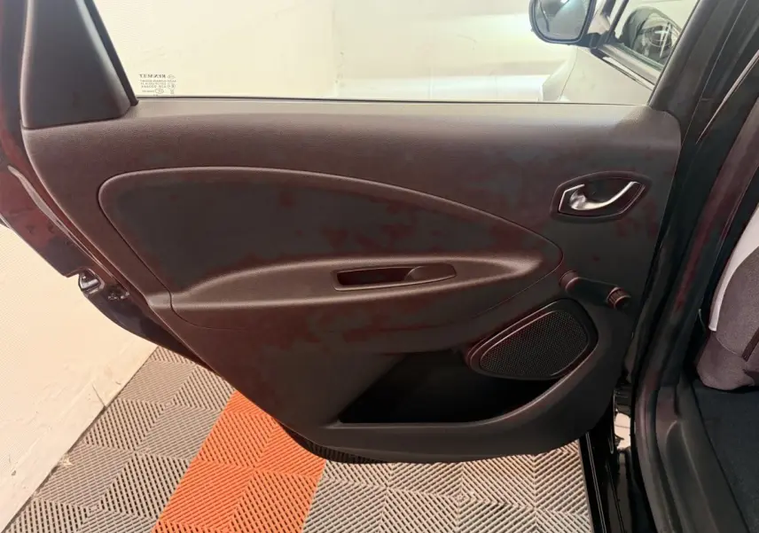 Vue intérieure de la porte arrière gauche noire d'une Renault ZOE 2024 avec poignée et haut-parleur intégrés.
