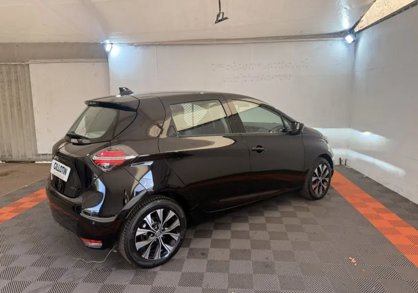 Renault ZOE noire vue 3/4 arrière droit dans un garage, avec jantes alliage et feux arrière LED distinctifs.