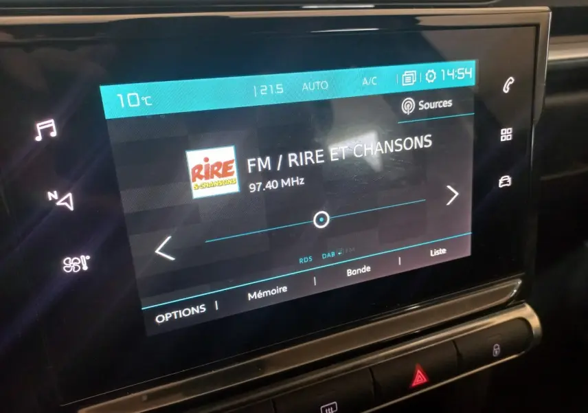 Écran tactile central de la Citroën C3 2024 affichant la radio FM sur fond noir intérieur.