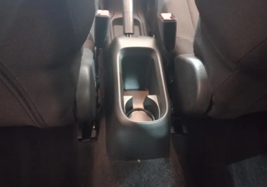 Vue rapprochée de la console centrale arrière noire entre les sièges avant du Citroën C3 2024.