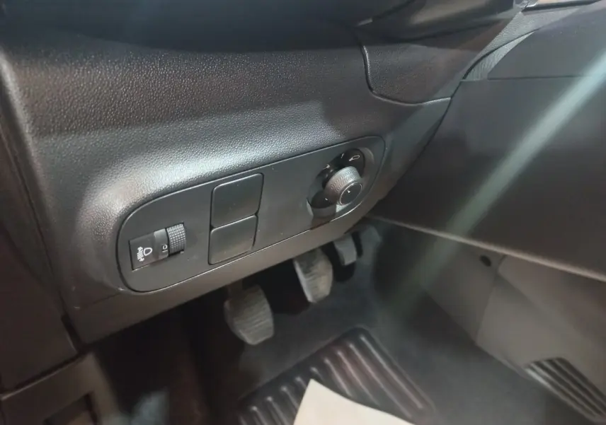 Vue intérieure côté conducteur de la Citroën C3 2024 noire, montrant les commandes d'éclairage et les pédales.