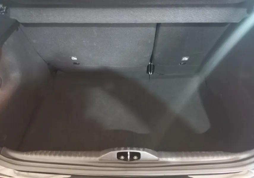Coffre ouvert vu de dessus de la Citroën C3 noire 2024, montrant l’espace de chargement et la banquette arrière rabattable.