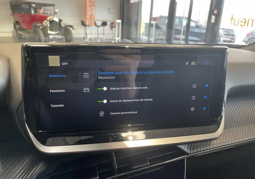 Écran tactile central du Peugeot 2008 bleu montrant les aides à la conduite dans un intérieur moderne.