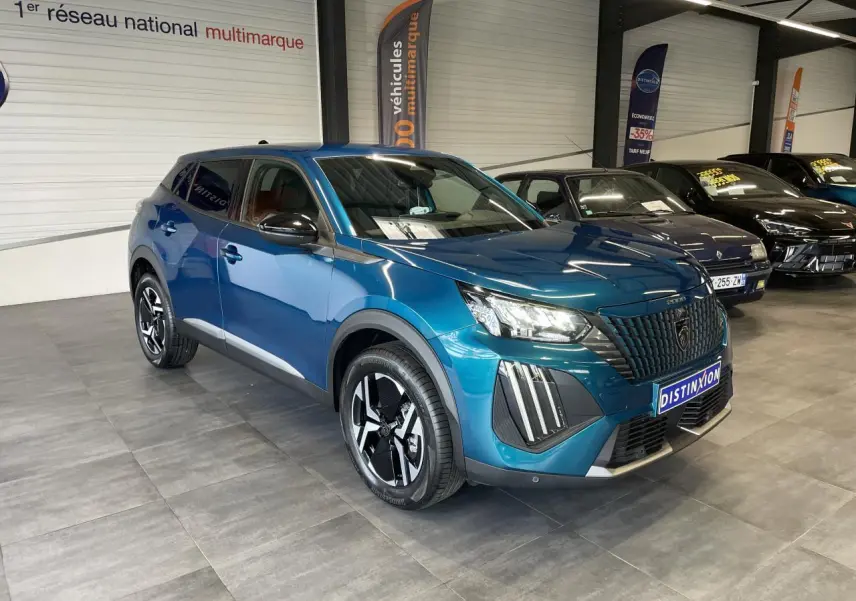 Peugeot 2008 bleu 3/4 avant droit en showroom, avec calandre noire et jantes alliage bi-ton.