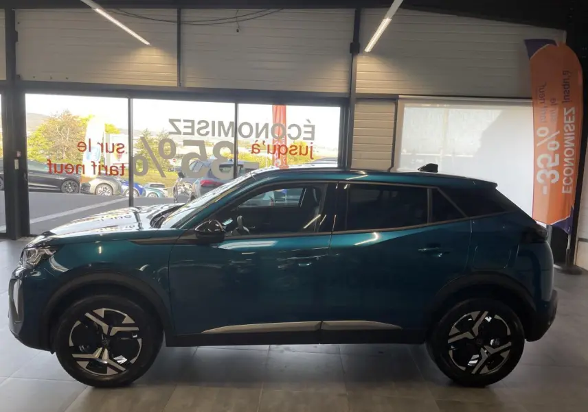 Peugeot 2008 bleu Obsession vue de profil côté gauche en intérieur avec jantes alliage bi-ton et toit noir.