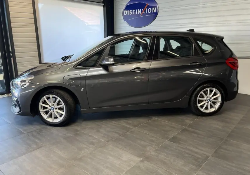 Profil côté gauche d'une BMW Série 2 Active Tourer gris métallisé de 2018, hybride essence avec jantes argentées.