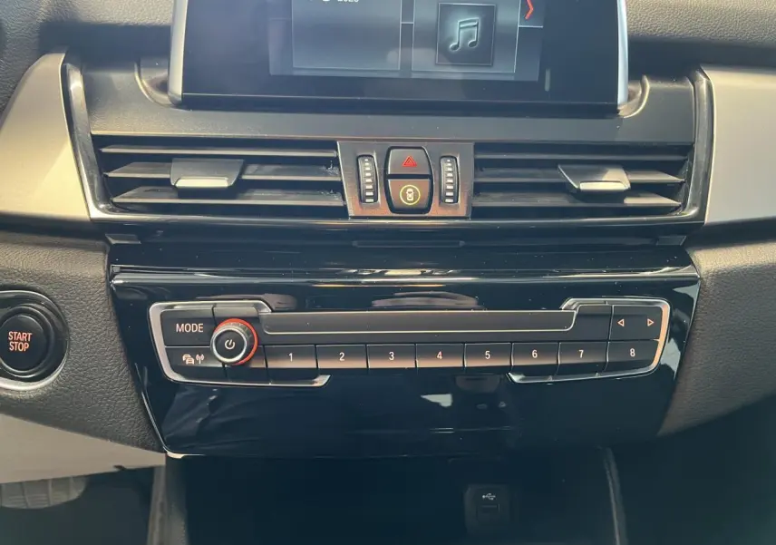 Vue rapprochée de la console centrale noire du BMW Série 2 225xe Active Tourer 2018 avec écran et commandes audio.