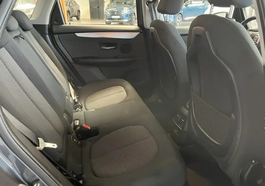 Vue intérieure arrière montrant les sièges tissu gris et les rangements au dos des sièges avant d'une BMW Série 2 Active Tourer 2018.