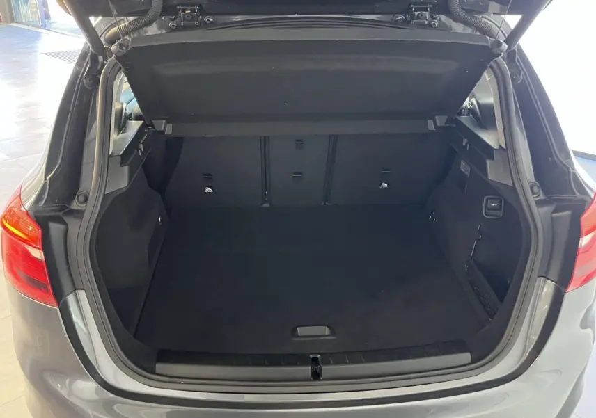 Coffre ouvert vu de l'arrière d'une BMW Série 2 Active Tourer gris 2018 avec intérieur spacieux et banquette rabattable.