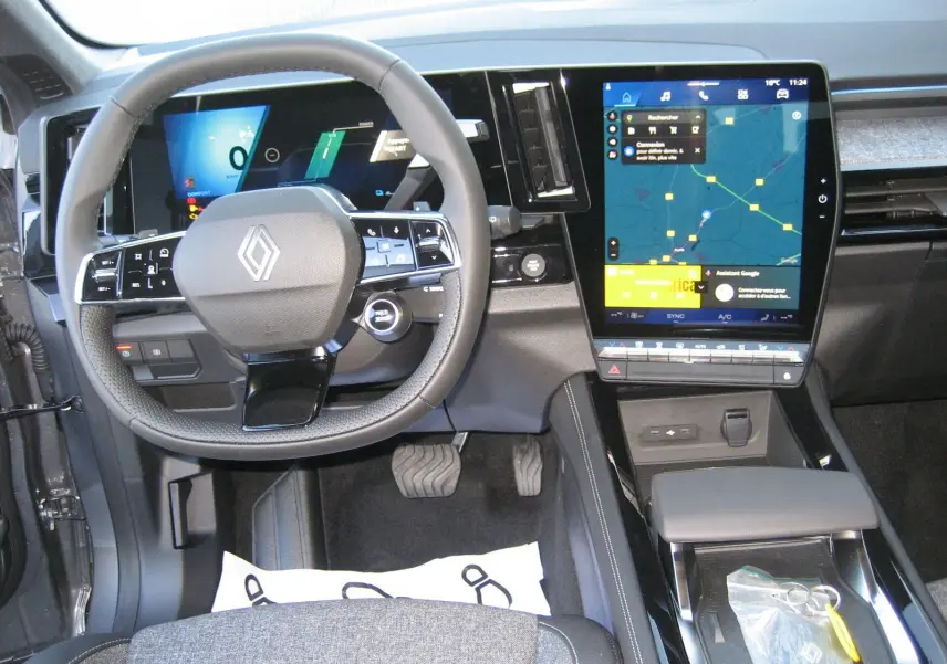 Vue intérieure du tableau de bord du Renault Austral gris schiste, avec écran tactile central et volant multifonction.
