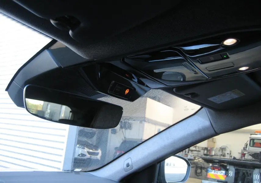Vue intérieure du rétroviseur et plafonnier du Renault Austral gris schiste, avec éclairage et capteurs visibles.