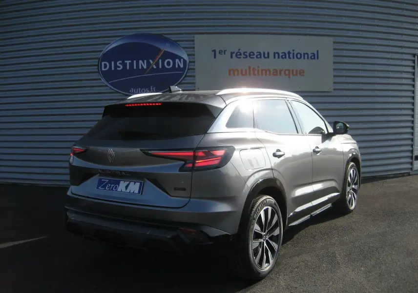 Vue 3/4 arrière droite du Renault Austral gris schiste avec feux LED et jantes bi-ton visibles au soleil.