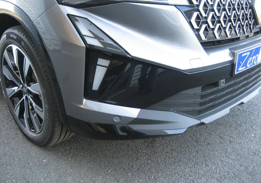 Gros plan sur l'avant droit gris schiste du Renault Austral PH.2 avec calandre hexagonale et jante noire brillante.
