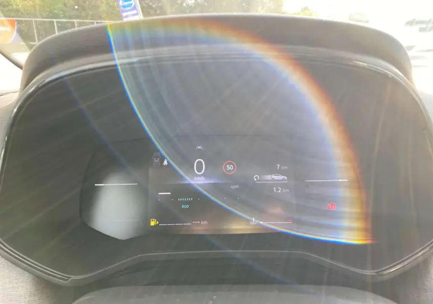 Compteur numérique couleur 7 pouces de Renault Clio 2025, affichant vitesse et alertes, avec reflet lumineux circulaire.