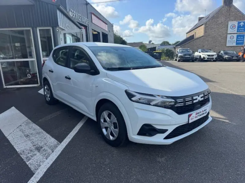 Vue 3/4 avant droite d'une Dacia Sandero blanche 2024 avec calandre noire et enjoliveurs d'origine