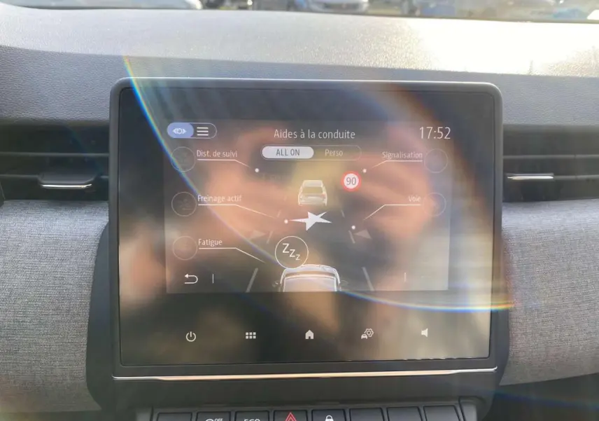 Écran tactile central de la Renault Clio 1.5 Blue dCi 2025 affichant les aides à la conduite, intérieur gris.
