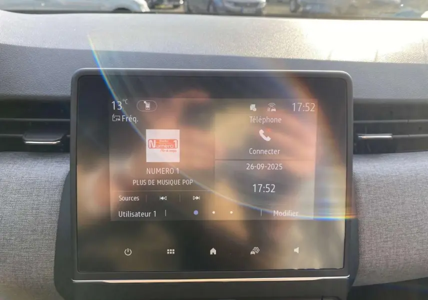 Écran tactile central de la Renault Clio 1.5 Blue dCi 2025 affichant radio et téléphone, vue frontale intérieure.