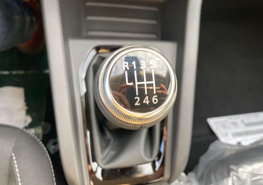 Gros plan sur le levier de vitesses manuel noir de la Renault Clio 1.5 Blue dCi 2025 avec marquages blancs.