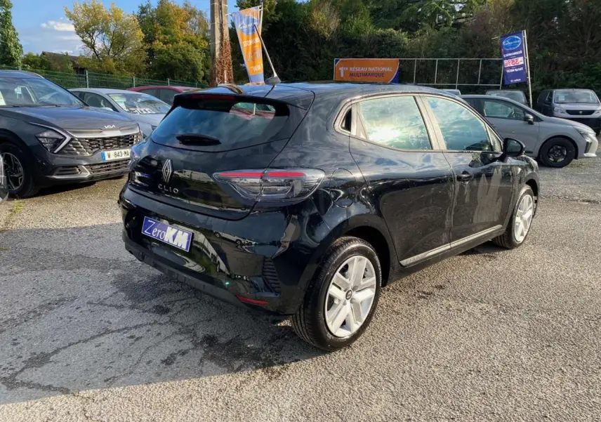 Vue 3/4 arrière droite d'une Renault Clio noire étoile 2025 avec feux LED et jantes argentées sur parking.