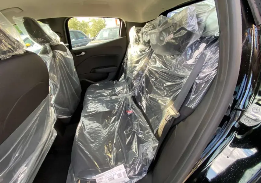 Vue intérieure côté droit de la banquette arrière noire protégée par des housses plastiques dans une Renault Clio 2025 Noir Étoile.